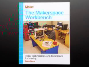 Front cover of "The Makerspace Workbench" by Adam Kemp. Cover photograph features a white man behind a workbench tinkering with computer guts.
