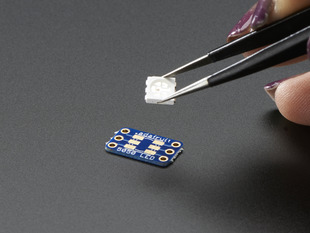 Hand holding 5050 size LED next to breakout board