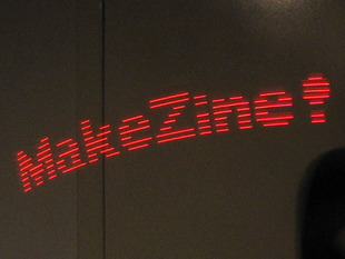 Mini POV long-capture image showing "MakeZine!" in red lights.