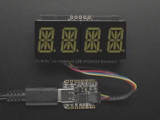 Overhead shot of an assembled 14-segment LED backpack, emitting the follow text in white LEDS: "AdaFruit 14-Segment Backpack"