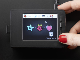 Red polished white hand holding a Faceplate and Buttons Pack placed on a Pi. 