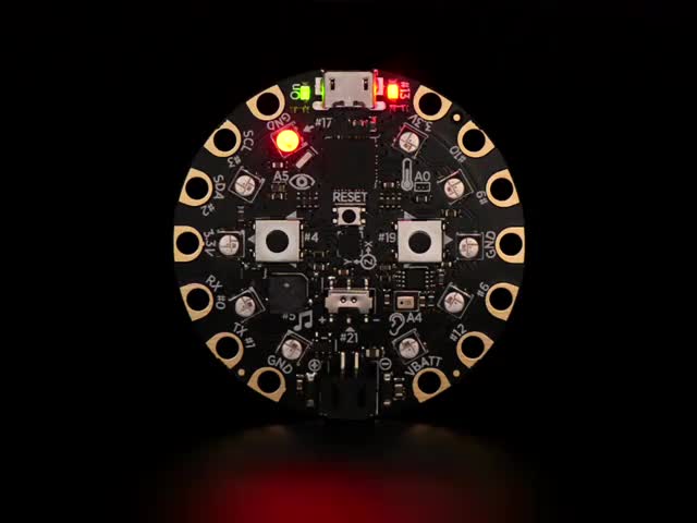 Video of a round microcontroller with lit up LEDs.