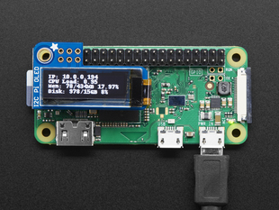 Top view of assembled and powered on Adafruit PiOLED - 128x32 Monochrome OLED on a Pi Zero. The OLED displays a data readout.