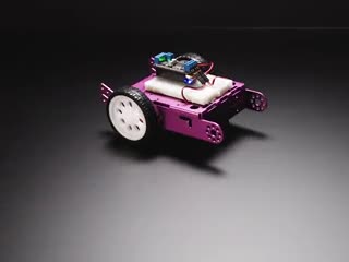 Rectanglular two-wheeled robot turning around a few times and then driving off.