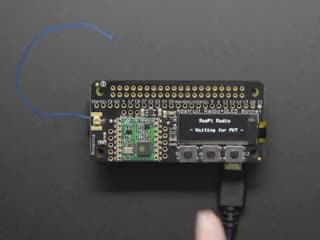 A rectangular microcontroller with OLED screen. A peach-manicured index finger presses buttons below the OLED screen, triggering different texts.