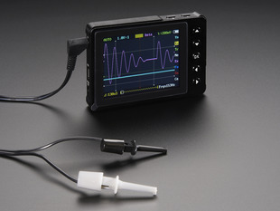 Angled shot of a DSO Nano v3 - Pocket-size color digital oscilloscope with hook probes. 
