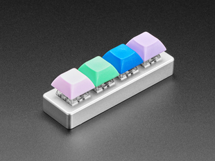 Angled shot of assembled 4-key aluminum keypad shell with key switches and colored keycaps.
