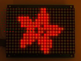 Red LED grid lit up with an adafruit logo