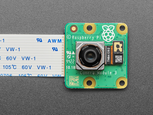 Overhead shot of green, square camera module with cable.