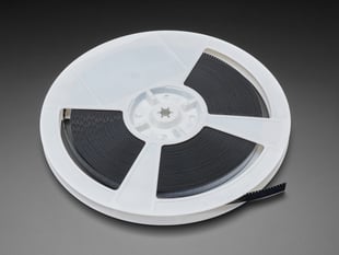 Angled shot of a white plastic reel containing microchips.