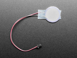 Overhead shot of small RTC battery with a JST connector with an adhesive sticker.