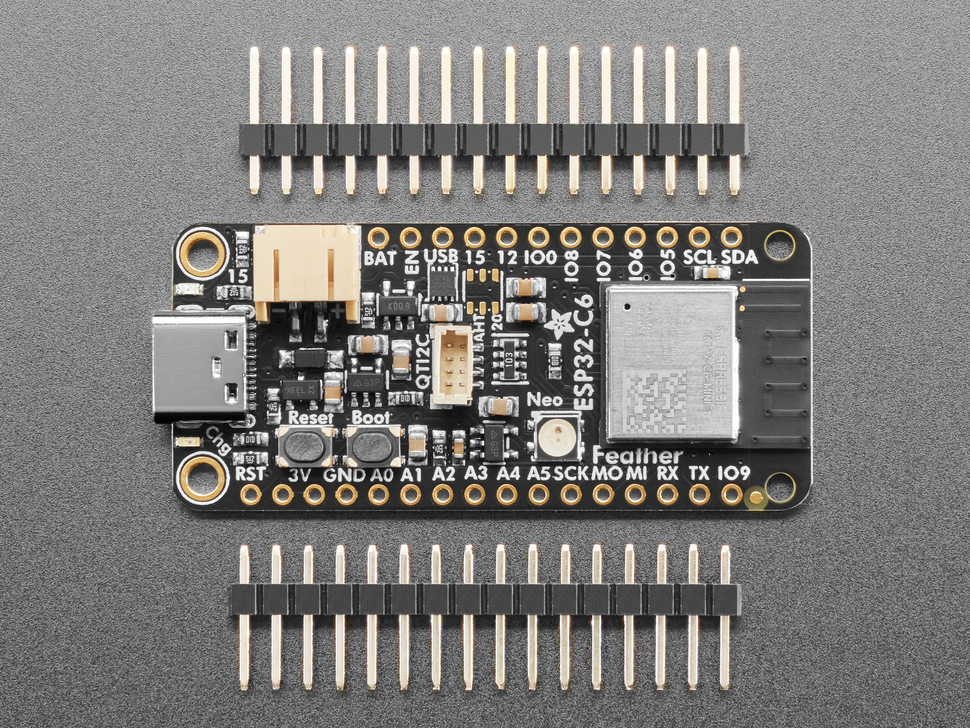 Overhead shot of rectangular dev board between two pieces of 16-pin header.