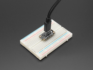 Angled shot of a long, rectangular USB-C assembled on a half-size breadboard with a USB-C cable.