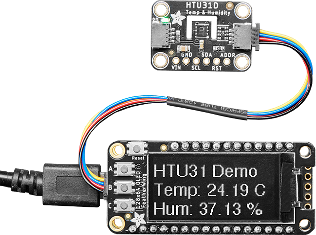 HTU31D Temperature and Humidity board connected to an OLED FeatherWing with STEMMA cable showing the temperature and humidity readings.